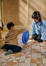 Load image into Gallery viewer, Parent and child playing together with the Stapelstein® Balance Board during indoor balance activities.