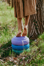 Load image into Gallery viewer, Child using Stapelstein® Original Cool stones as seats and balance steps during active play.