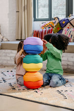 Load image into Gallery viewer, Children playing with the Stapelstein® Original Rainbow Classic set of 6 colourful stacking stones. Encourages balance, movement and imaginative play while being safe, climate-neutral and recyclable. Delivery in Malta & Gozo.