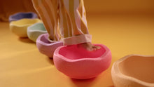 Load image into Gallery viewer, Child stepping on Stapelstein® Original Rainbow Pastel stones while playing an indoor balance game.