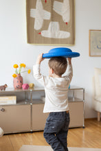 Load image into Gallery viewer, Child playing independently with the Stapelstein® Balance Board in a bright playroom.