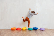 Load image into Gallery viewer, Child stepping on bright Stapelstein® Rainbow Classic stacking stones during a balance game.