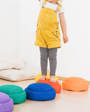 Load image into Gallery viewer, Child stepping on bright Stapelstein® Rainbow Classic stacking stones during a balance game.