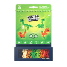 Load image into Gallery viewer, Packaging of a 'Puzzle by Number' activity pad with dinosaur illustrations on a green background.
