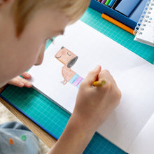 Load image into Gallery viewer, Tiger Tribe How to Draw – Dinosaurs – lifestyle shot of child drawing – the outdoor kid.
